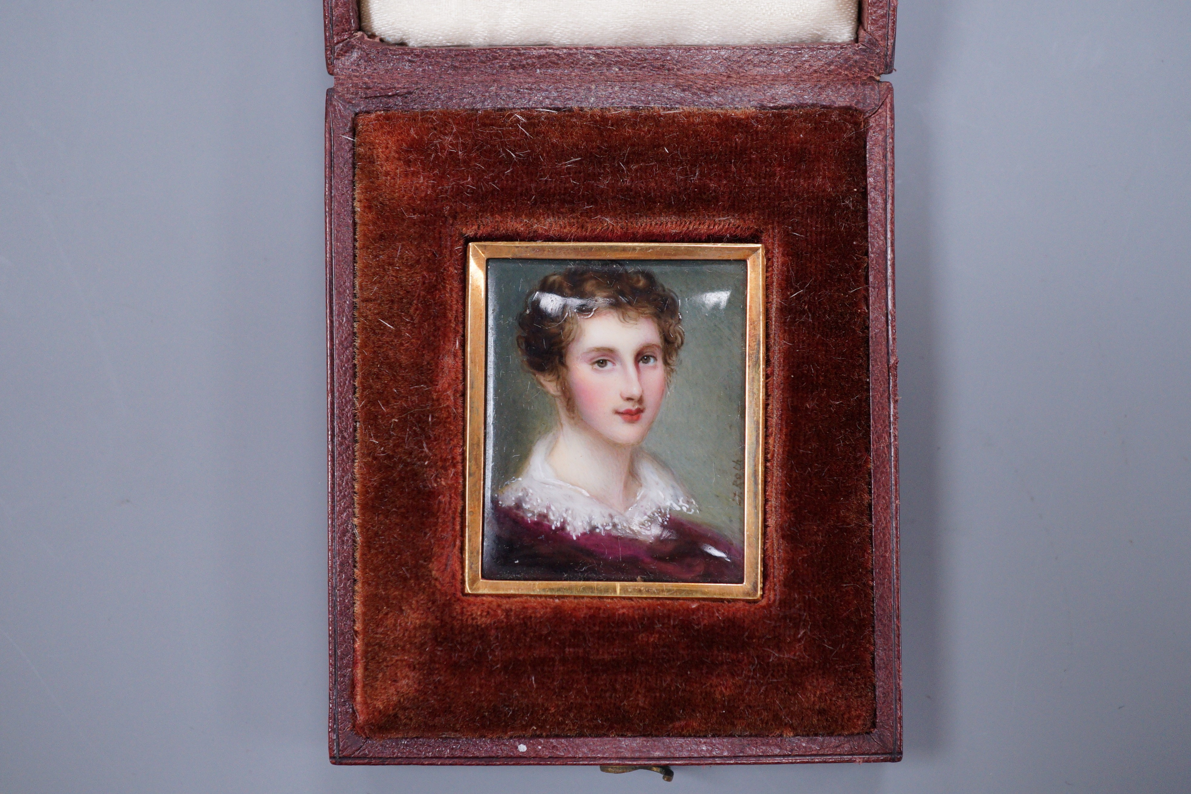 J. Roth, a gold framed enamelled miniature portrait of a gentleman with lace collar, signed 3.5 x 3cm, in fitted leather case